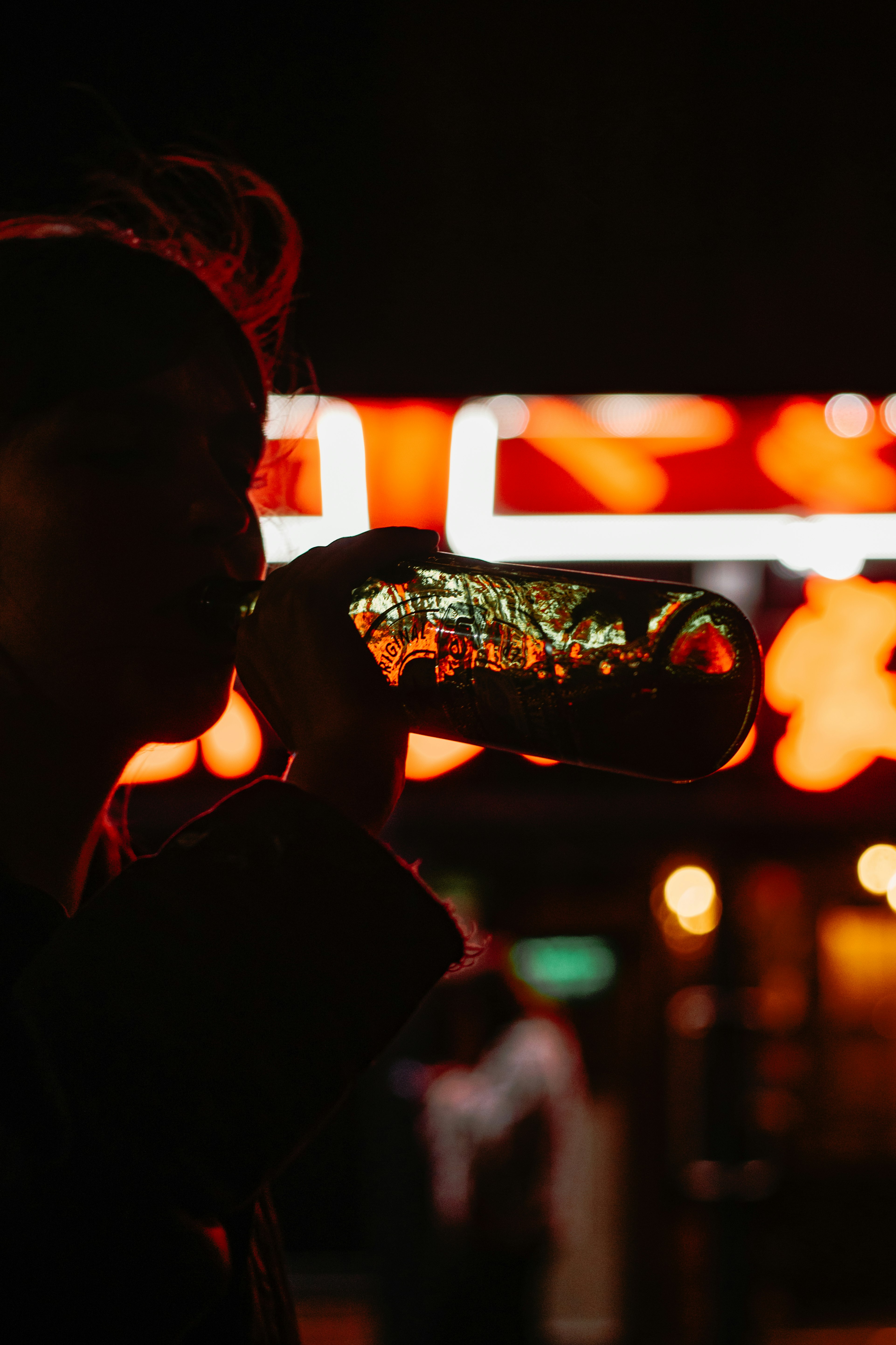 man drinking from a black can